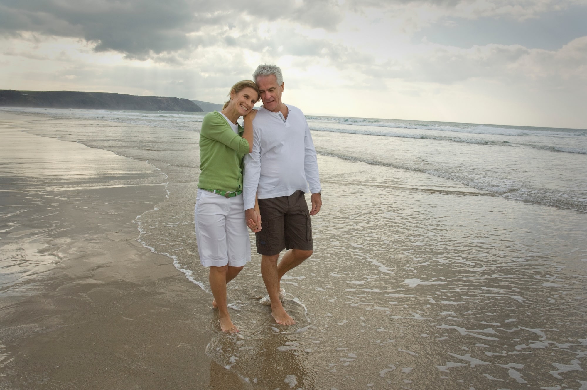 happy retired couple enjoying beach